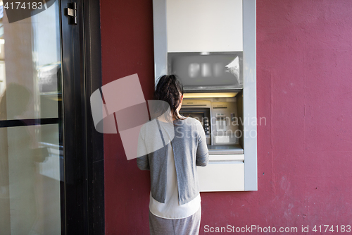 Image of close up of woman at atm machine outdoors