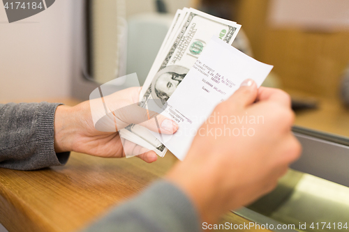 Image of customer with money and receipt at bank counter