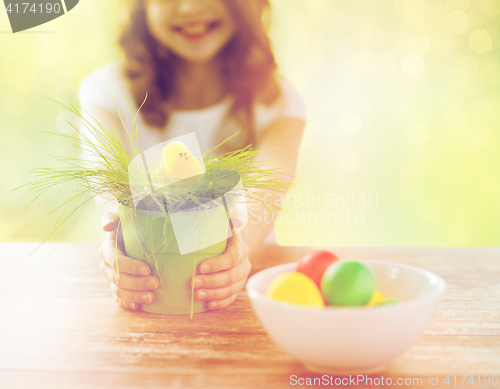 Image of close up of girl holding pot with toy chicken