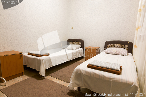 Image of The interior of a small room with two beds
