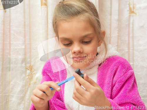 Image of Seven-year girl on a stack makes drawing Crafts from clay