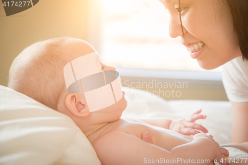 Image of Mixed Race Chinese and Caucasian Baby Boy Laying In Bed with His