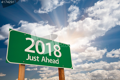 Image of 2018 Green Road Sign Over Clouds