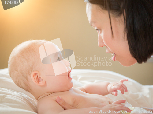 Image of Mixed Race Chinese and Caucasian Baby Boy Laying In Bed with His