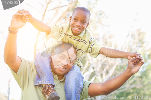 Image of Happy African American Father and Son Riding Piggyback Outdoors