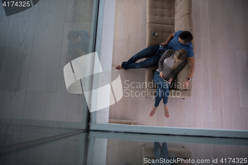 Image of youg couple in living room with tablet top view