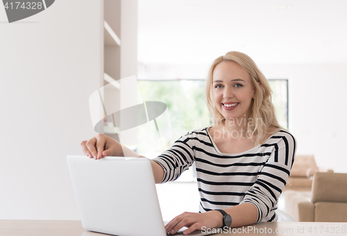 Image of Young woman with laptop at home