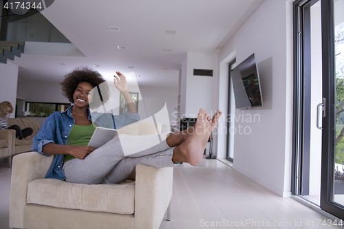 Image of african american woman at home with digital tablet