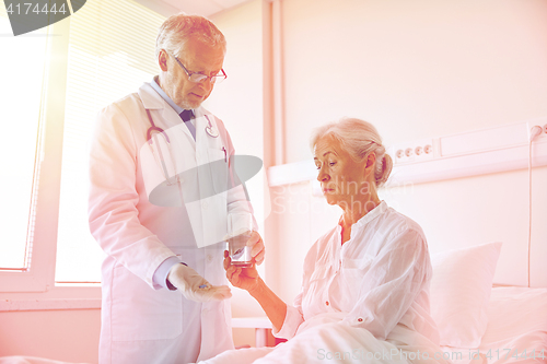 Image of doctor giving medicine to senior woman at hospital