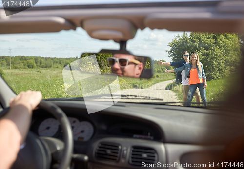 Image of couple hitchhiking and stopping car on countryside