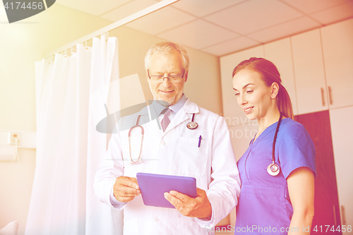 Image of senior doctor and nurse with tablet pc at hospital