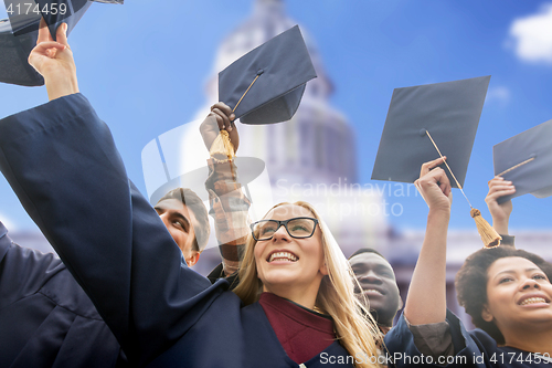 Image of happy students or bachelors waving mortar boards