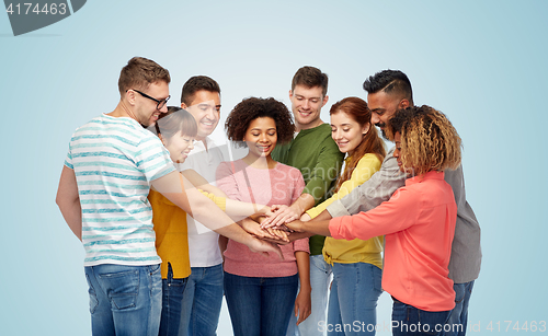 Image of international group of happy people holding hands