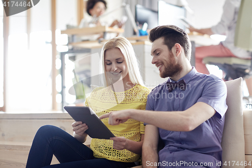 Image of happy creative team with tablet pc in office