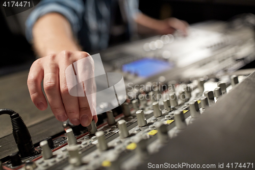 Image of man using mixing console in music recording studio