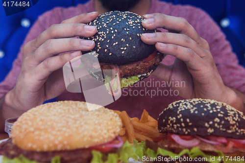 Image of Man eating burgers
