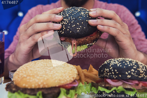 Image of Man eating burgers