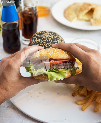 Image of Man eating burgers