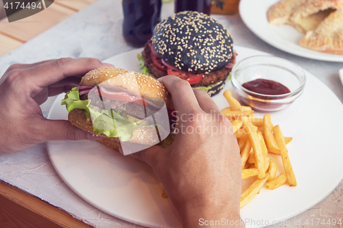 Image of Man eating burgers