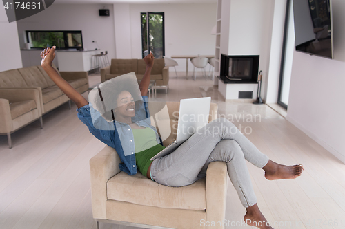 Image of African American women at home in the chair using a laptop