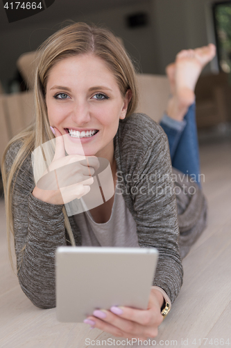Image of young women used tablet computer on the floor