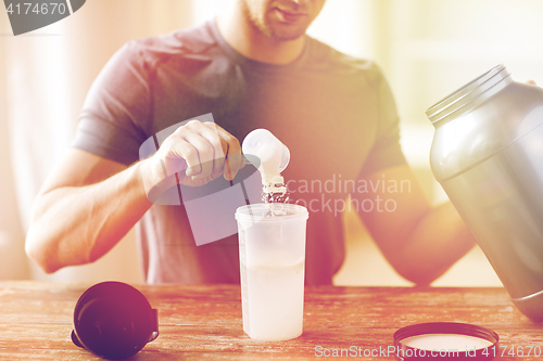 Image of close up of man with protein shake bottle and jar