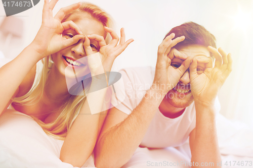 Image of happy couple lying in bed at home