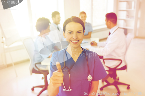 Image of happy doctor over group of medics at hospital