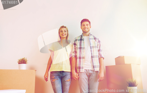 Image of smiling couple with big boxes moving to new home