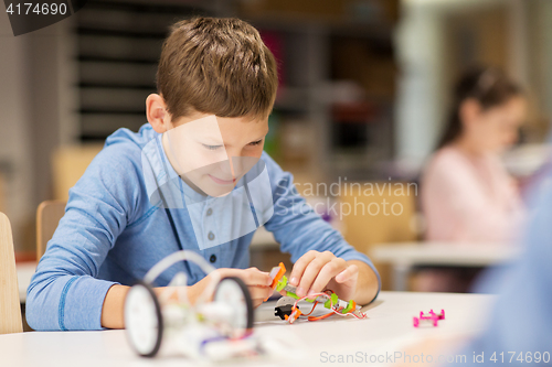 Image of close up of boy building robot at robotics school