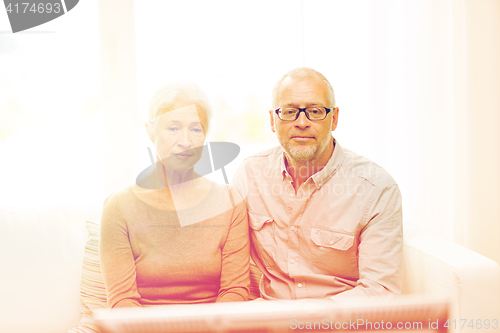 Image of senior couple watching tv at home