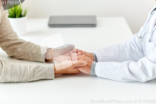 Image of close up of doctor holding old man hand