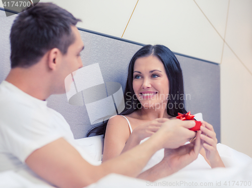 Image of man giving woman little red gift box