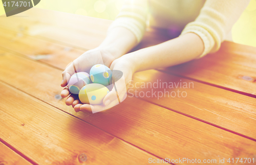 Image of close up of woman hands with colored easter eggs