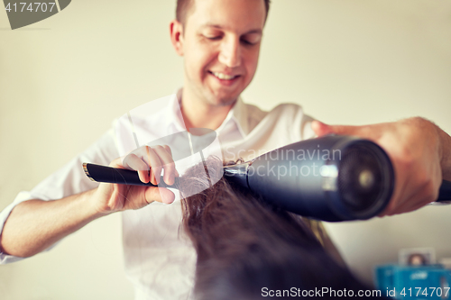 Image of  close up of stylist making hairdo at salon