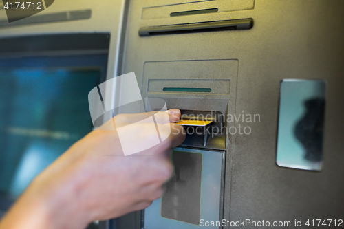 Image of close up of hand inserting card to atm machine