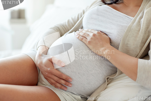 Image of close up of pregnant woman lying in bed at home