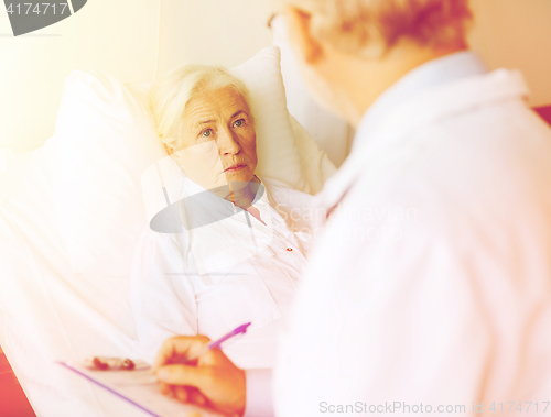 Image of senior woman and doctor with clipboard at hospital