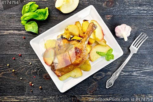 Image of Duck leg with apple and potatoes on board top