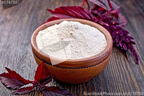 Image of Flour amaranth in clay bowl with flower on dark board