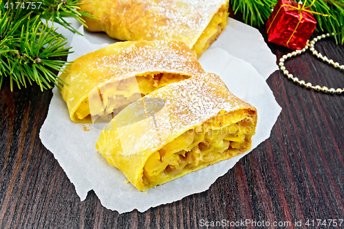 Image of Strudel pumpkin and apple with pine branches on wooden board