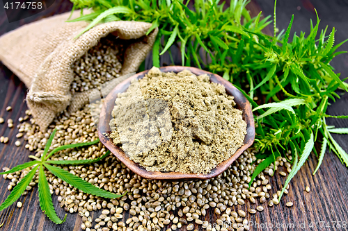 Image of Flour hemp in bowl with grain in bag on dark board