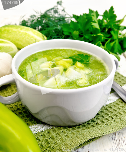Image of Soup cucumber with parsley in white bowl on board