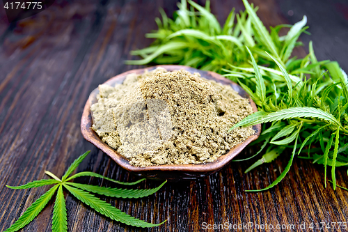 Image of Flour hemp in clay bowl with leaf on dark board