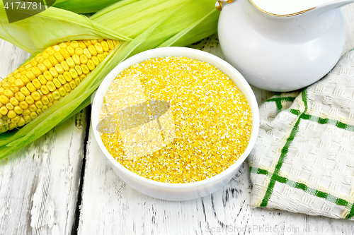 Image of Corn grits in white bowl on board 