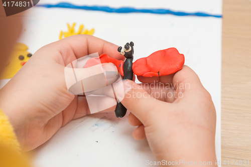 Image of Child sculpts from clay butterfly, close-up