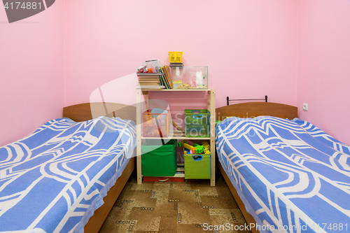 Image of The interior of a small dorm room with two beds and a homemade rack in the middle