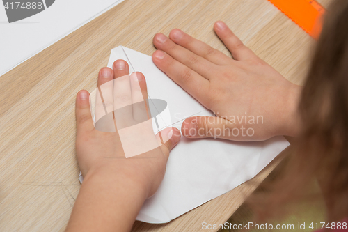 Image of Girl is engaged in origami, make a paper airplane