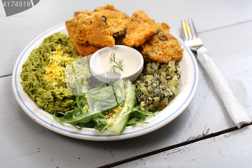 Image of Oyster topped with bread crumbs a puree of green peas 