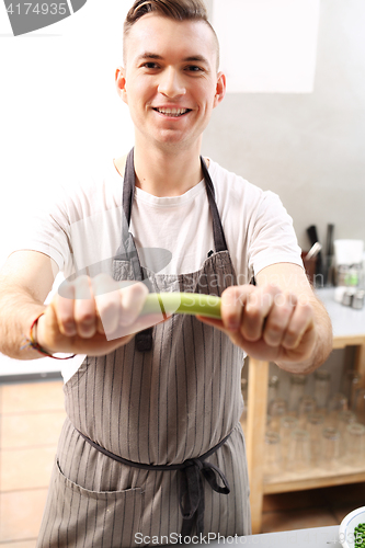 Image of The cook holds in his hand a vegetable.